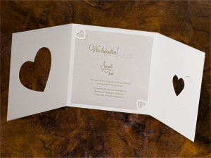 Aufgeklappte Karte – vergrößerte Abbildung Abbildung der aufgeklappten Hochzeitseinladung. Zu sehen ist der Altarfalz und die beiden gestanzten Herzen.
