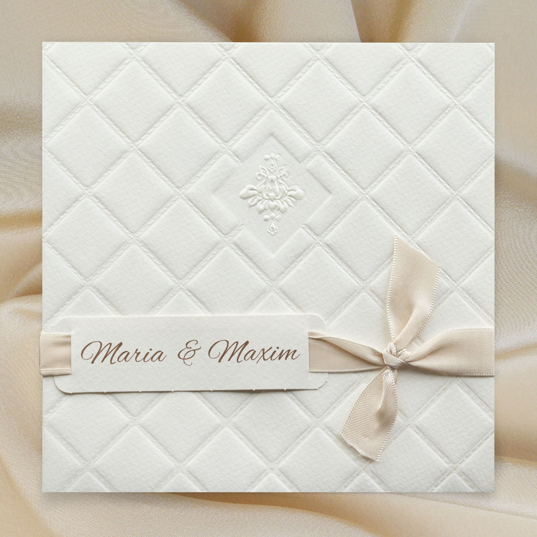 Vergrößerte Abbildung Romantische Hochzeitseinladung mit Prägungen und Schleife vor Stoffhintergrund.