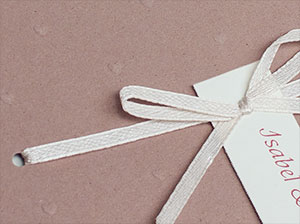 Detailaufnahme der Schleife – vergrößerte Abbildung Weiße Schleife mit Hochzeitseinladung.